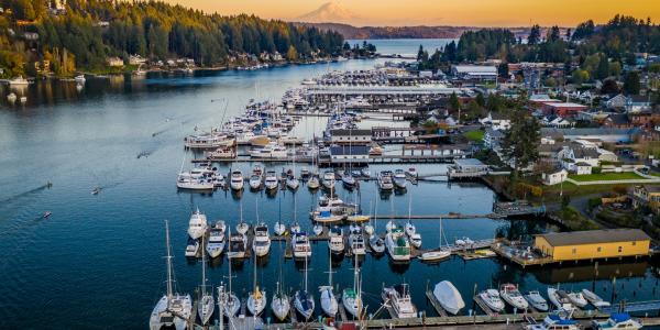 A drone view of boats in Gig Harbor, Washington at sunset with Mt Rainier in the background.